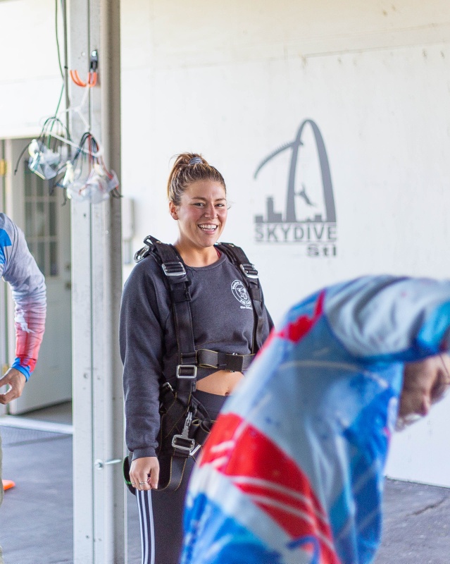 Woman wearing skydiving equipment and prepping for her first tandem skydive at Skydive St Louis near Chicago